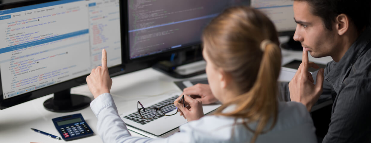 Man and woman looking at computer code