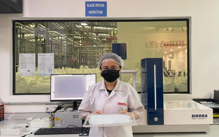 Angel Loh, chemist at Hiroyuki with rPET pellet samples to be inspected by the Purity Concept V system